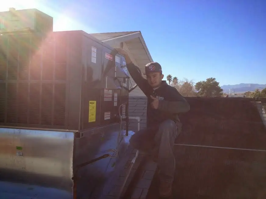 HVAC technician performing AC Tune-Up on a rooftop unit in Columbia Heights